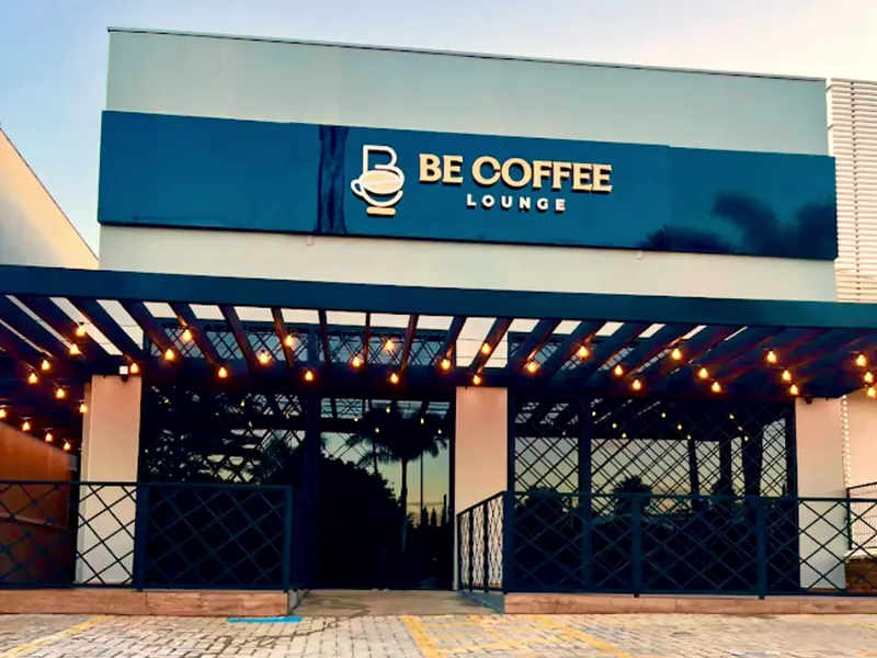 Fachada do Be Coffee Lounge com a pérgola iluminada